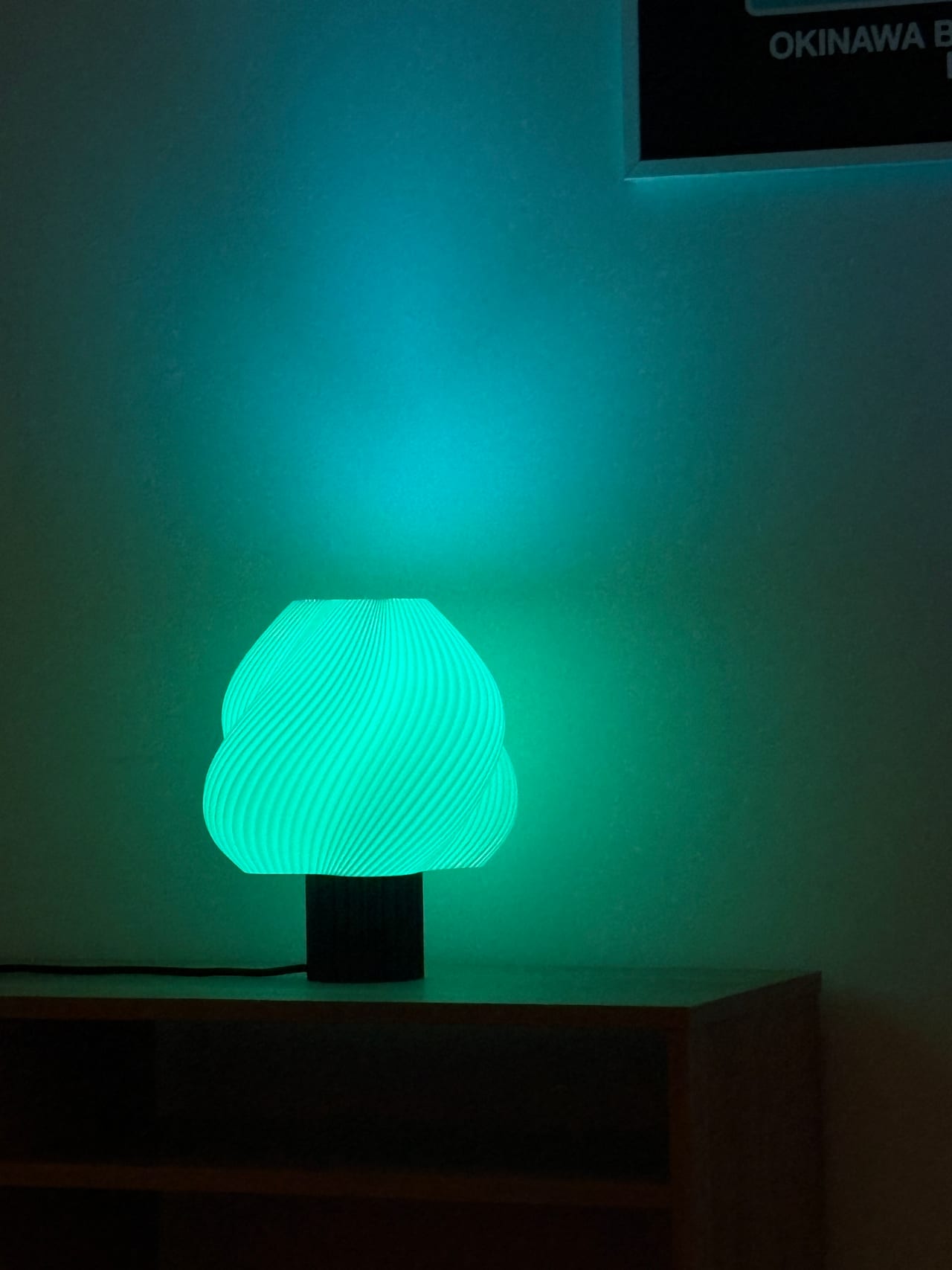 Lumo lamp met smart-bulb in teal, close-up tegen een wand